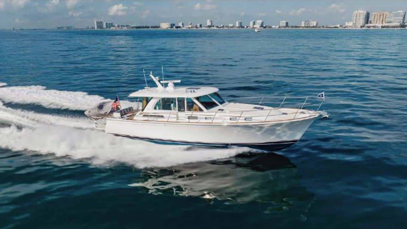 Luxury yacht cruising in Miami with city skyline in background.