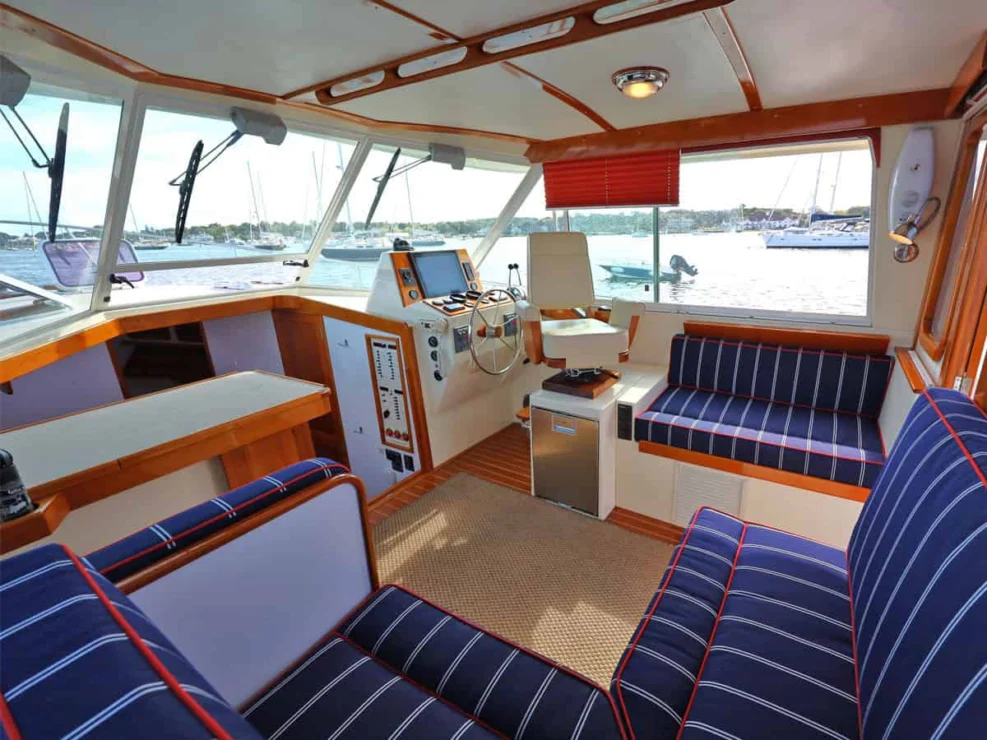 Image of REPETE, 2004 Bruckmann Bluestar 37, view of pilothouse to starboard with settee behind helm.