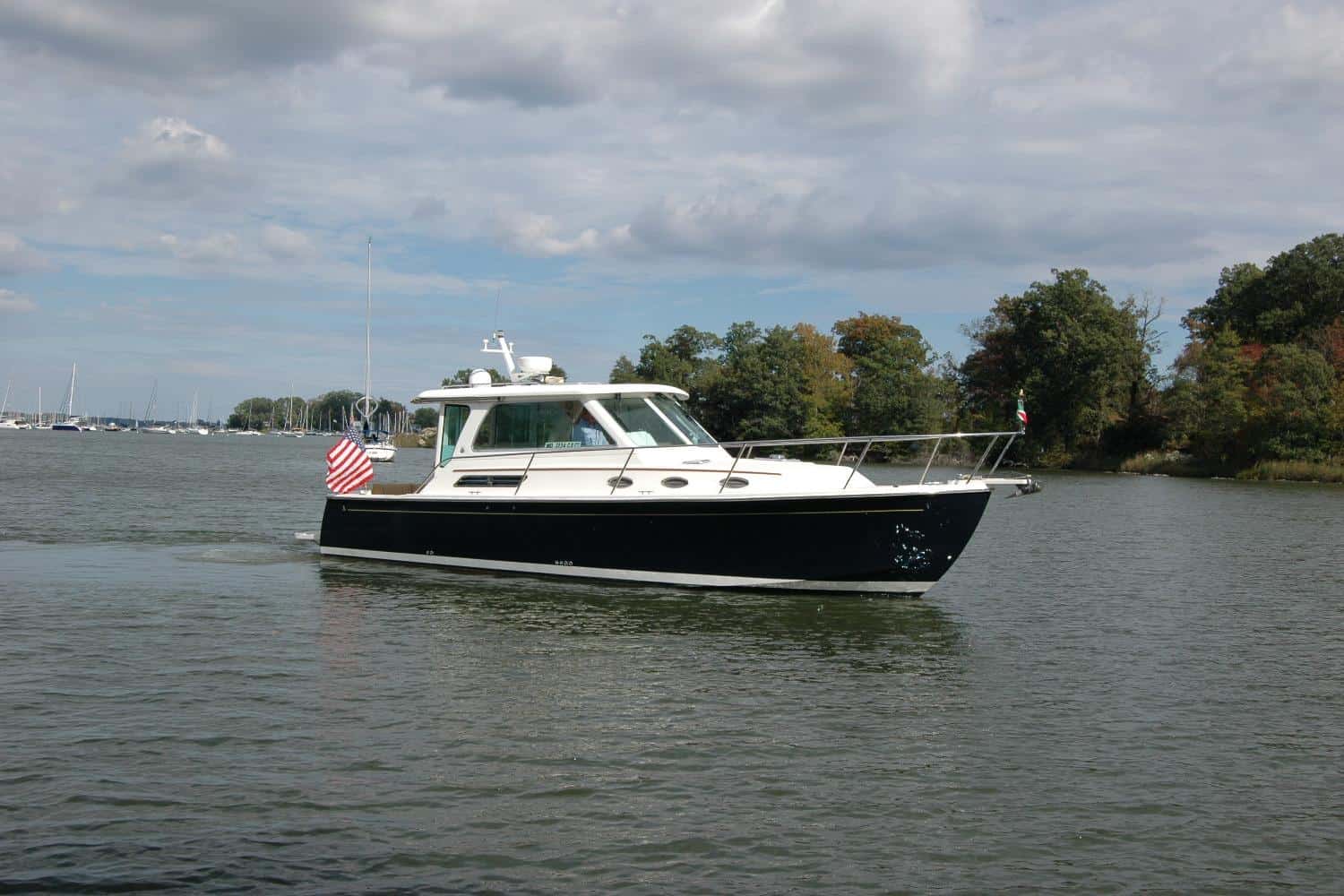 2014 Back Cove 34 Downeast cruiser yacht AU LAPIN AGILE featuring a dark blue hull cruising on calm water with an American flag on the stern