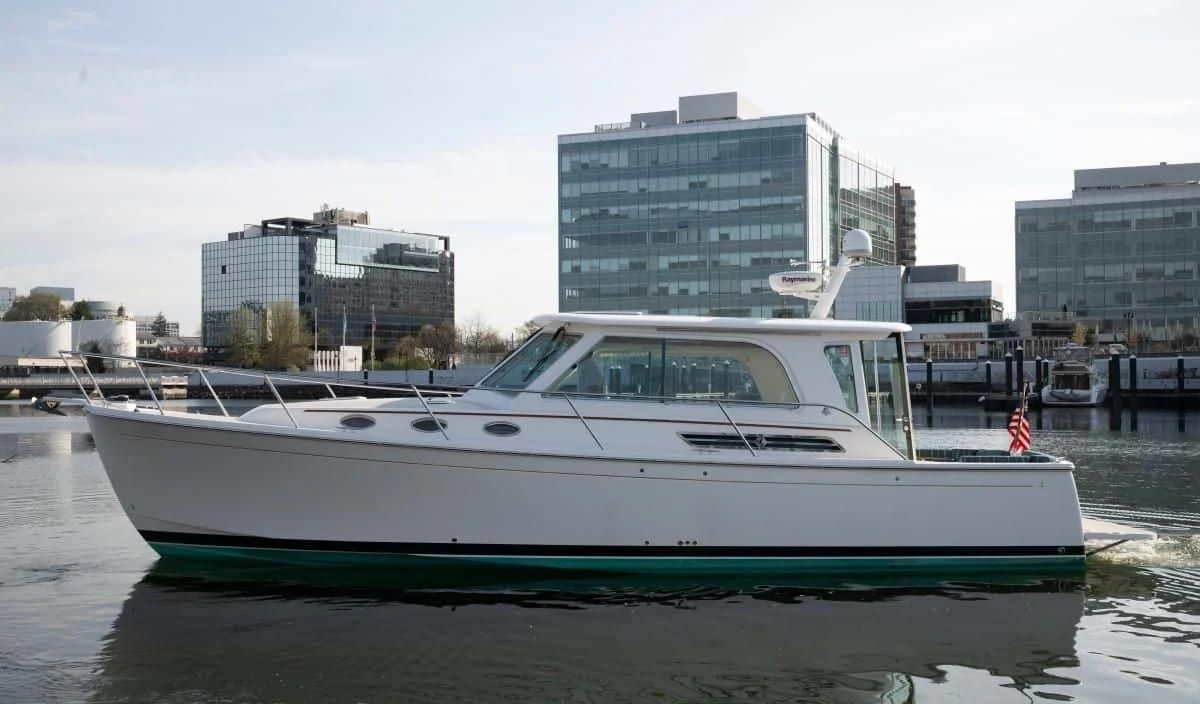 2014 Back Cove 37 Downeast yacht Happy Hour cruising on the water with a city skyline backdrop