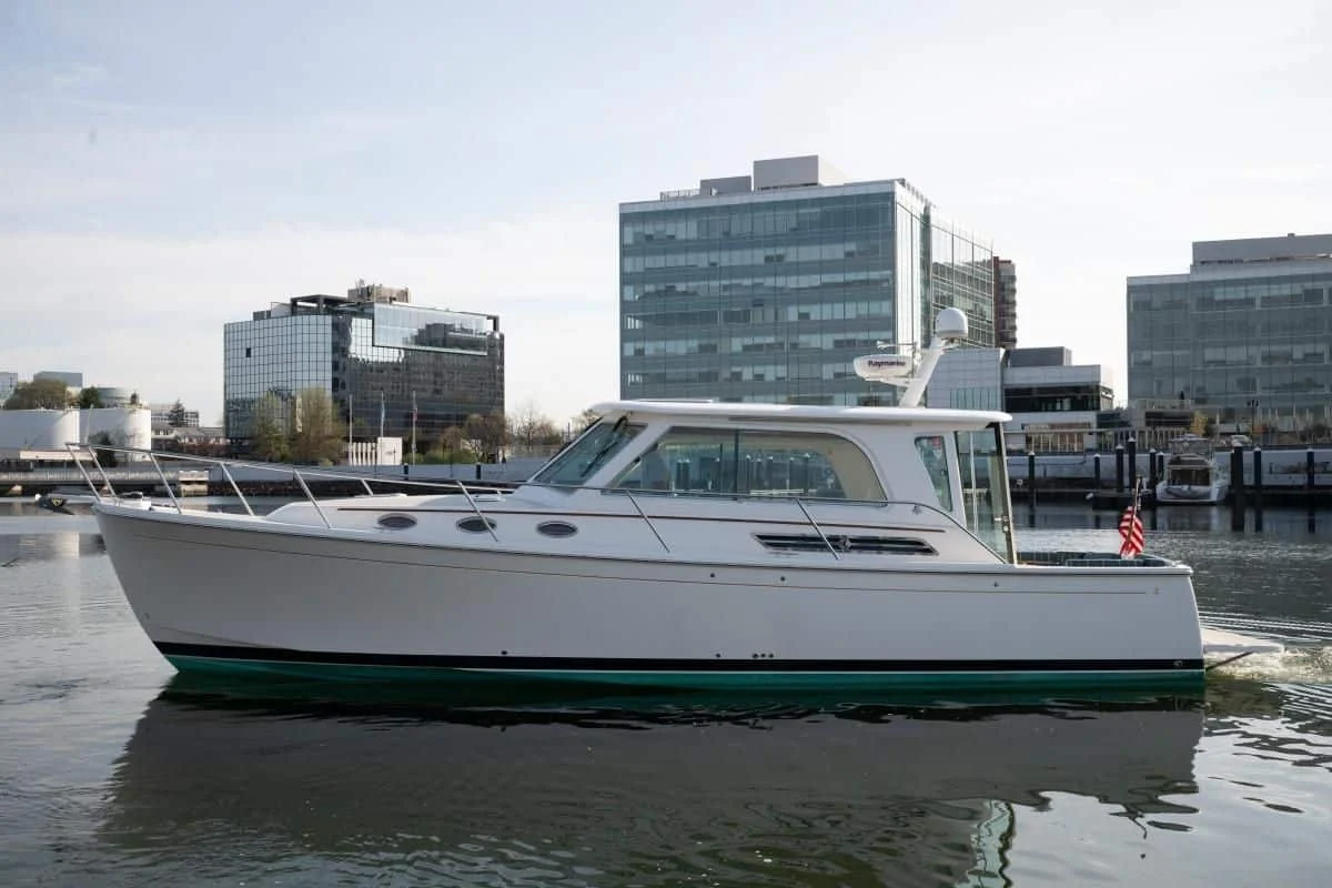2014 Back Cove 37 Downeast yacht Happy Hour cruising on the water with a city skyline backdrop