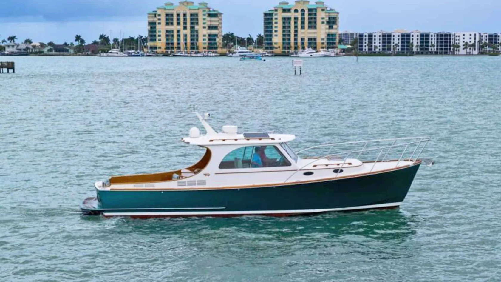 2014 Hinckley Picnic Boat 37 MKIII motor yacht RAMBLER II cruising on the water, showcasing its classic forest green hull, varnished teak toerail, and white pilothouse.