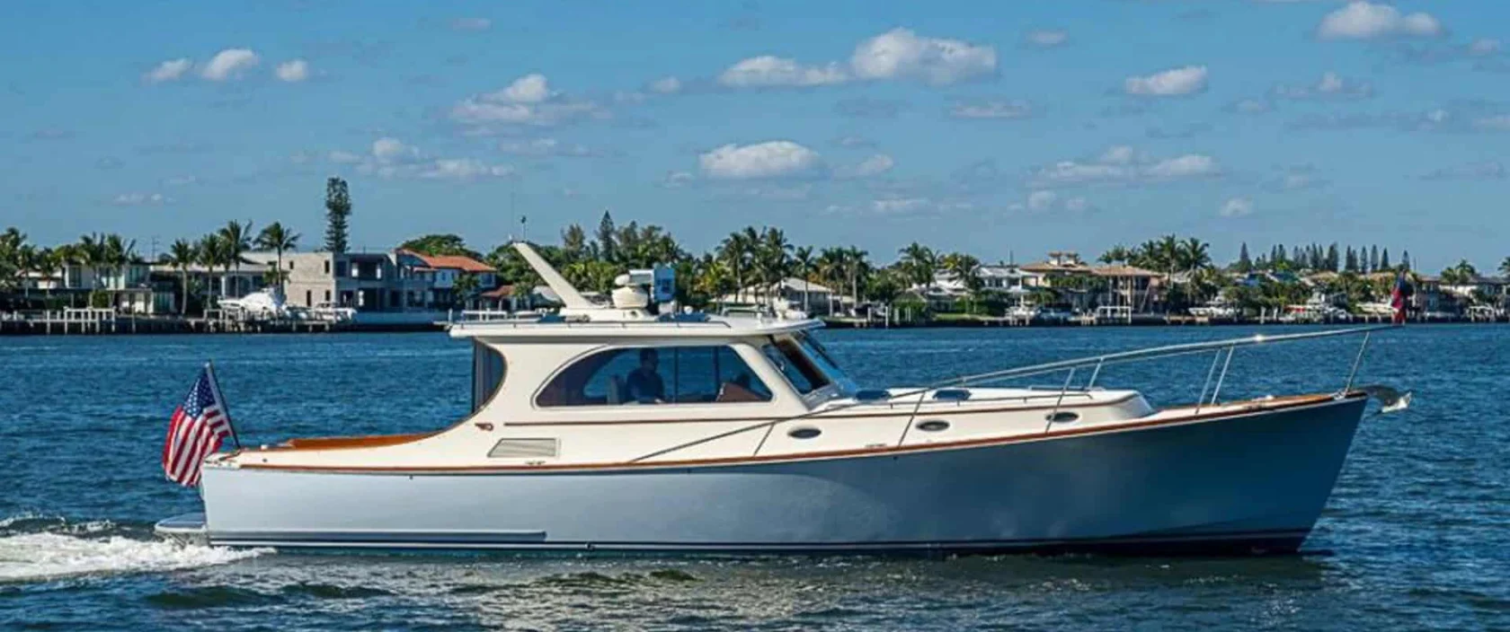 2008 Hinckley Talaria 44 motor yacht SKYLARK cruising on the water in West Palm Beach, Florida, showcasing its light blue hull and classic profile.