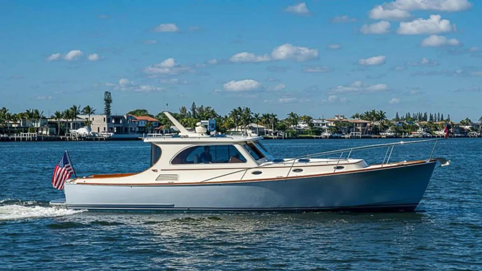 2008 Hinckley Talaria 44 motor yacht SKYLARK cruising on the water in West Palm Beach, Florida, showcasing its light blue hull and classic profile.