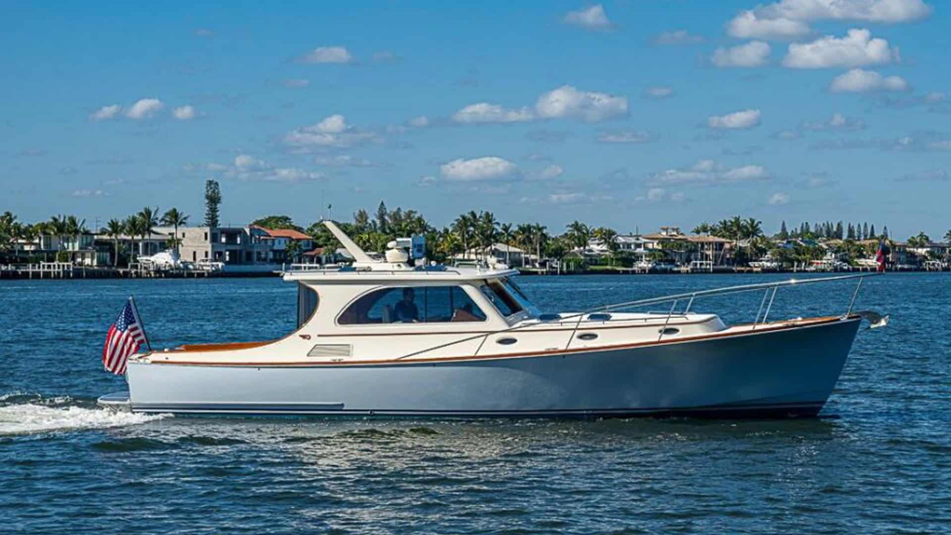 2008 Hinckley Talaria 44 motor yacht SKYLARK cruising on the water in West Palm Beach, Florida, showcasing its light blue hull and classic profile.