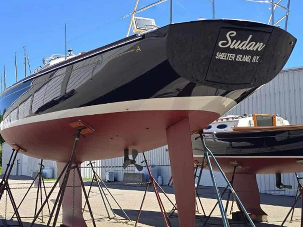 Stern view of the Alerion 41 Sudan on stands, showing the dark blue transom, deep fin keel, and feathering propeller.