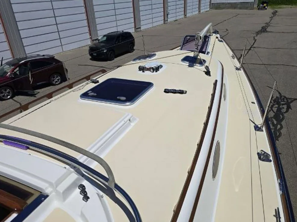 View looking forward along the clean tan non-skid deck and cabin top hatches of the Alerion 41.