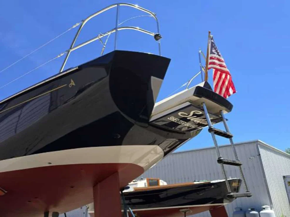 Low-angle view of the Alerion 41 stern transom showing the lowered swim ladder and American flag.