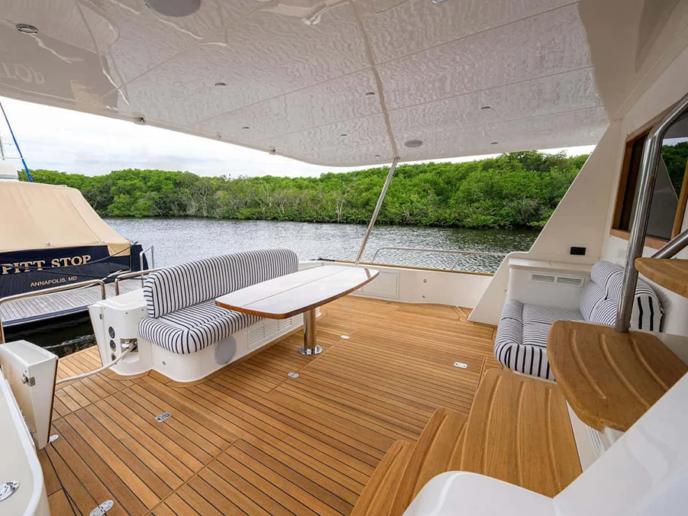 Wide view of the teak aft cockpit dining and lounge area on the Grand Banks GB60 motor yacht