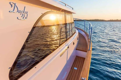 Duchy 35 motor yacht, close up view of starboard side deck, rails on the water.