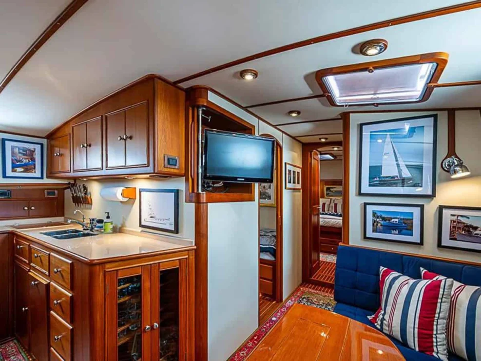2001 Grand Banks Eastbay 46 Sweet salon with large settee, hi-low table and tv.